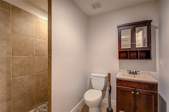 bathroom featuring vanity, toilet, and tiled shower