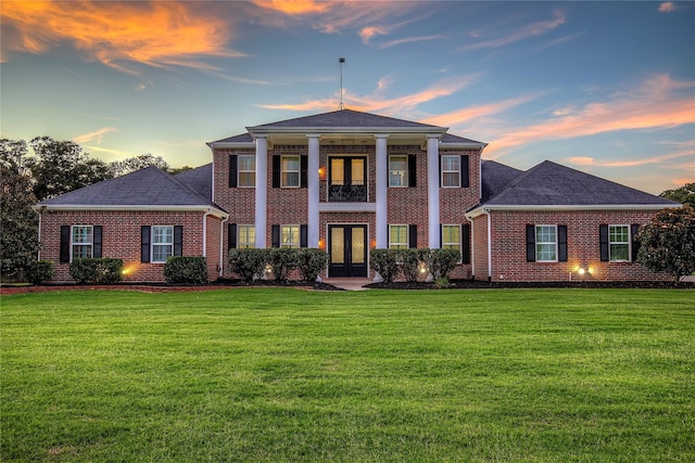 greek revival inspired property featuring a yard and french doors