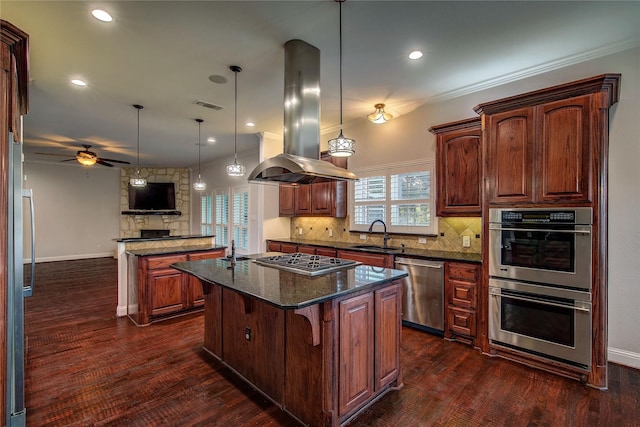 kitchen featuring hanging light fixtures, dark stone counters, a kitchen island, island exhaust hood, and stainless steel appliances