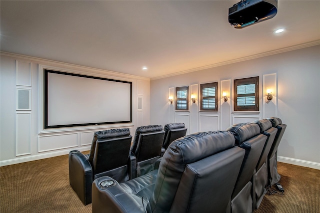 cinema room featuring ornamental molding and dark carpet