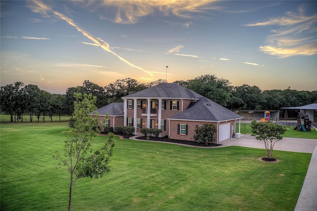 view of front of house with a garage and a yard