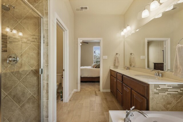 full bathroom featuring vanity, wood-type flooring, shower with separate bathtub, and toilet