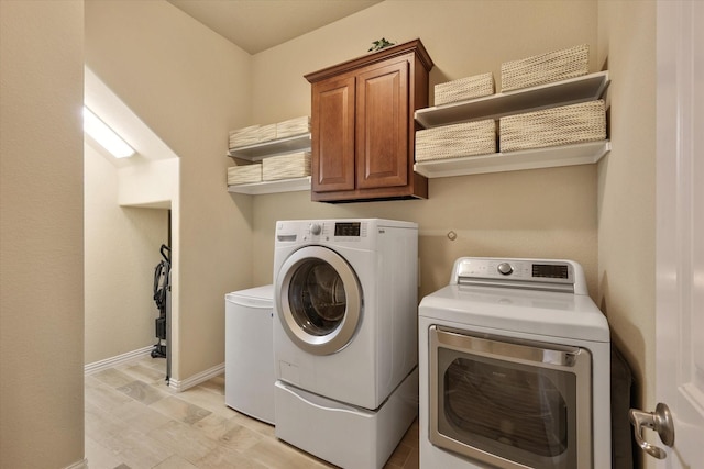 laundry room with washer and dryer and cabinets