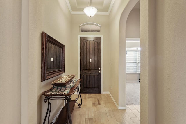 foyer entrance with light hardwood / wood-style floors and ornamental molding