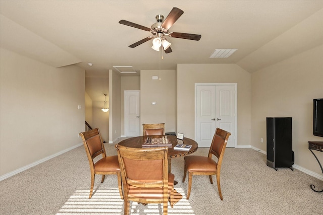 carpeted dining room with ceiling fan and lofted ceiling