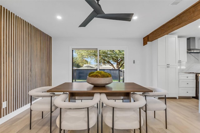 dining area with beam ceiling, light hardwood / wood-style flooring, and ceiling fan