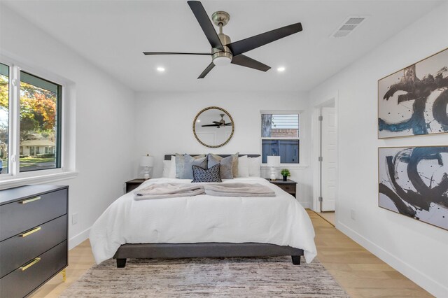 bedroom featuring multiple windows, ceiling fan, and light wood-type flooring