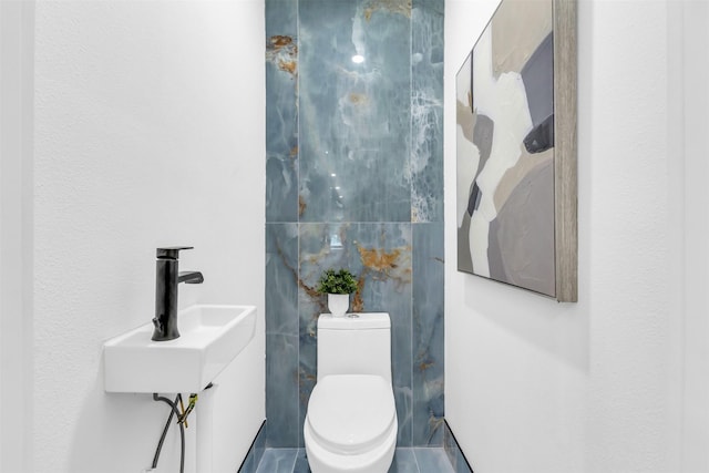 bathroom featuring tile patterned flooring, toilet, and sink