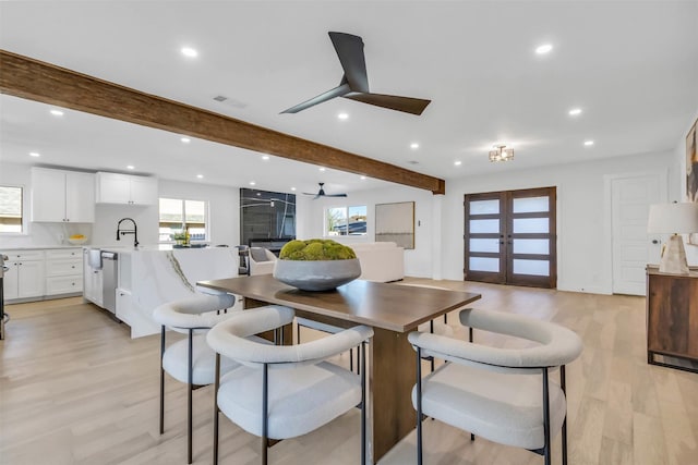 dining space featuring beamed ceiling, ceiling fan, light hardwood / wood-style floors, and french doors