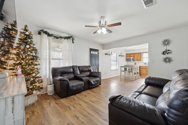 living room with light hardwood / wood-style floors and ceiling fan