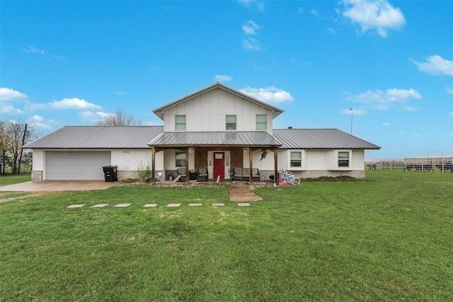 view of front of property featuring a garage, a front yard, and covered porch