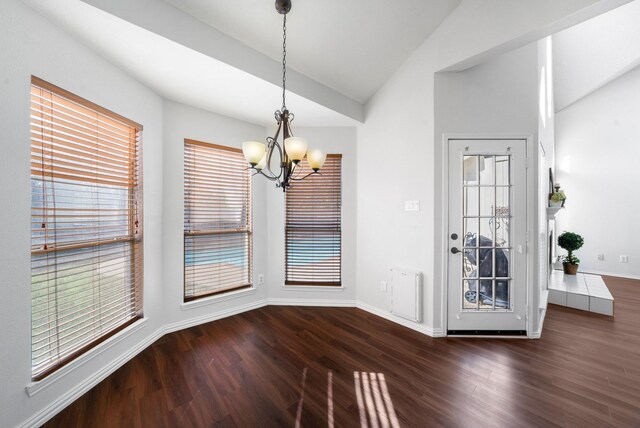 unfurnished dining area featuring lofted ceiling, dark wood-type flooring, and a wealth of natural light