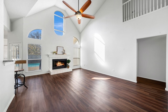 unfurnished living room featuring ceiling fan, high vaulted ceiling, and dark wood-type flooring