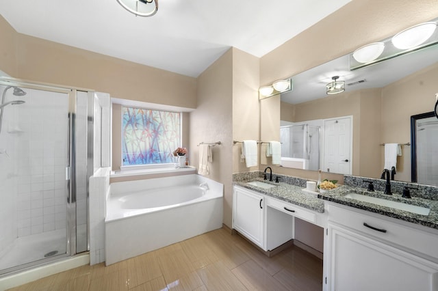 bathroom with vanity and shower with separate bathtub