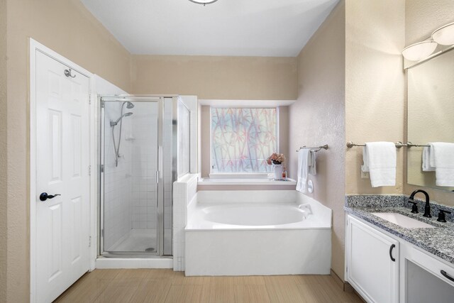 bathroom with vanity and independent shower and bath