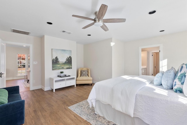 bedroom with ceiling fan, ensuite bathroom, and wood-type flooring