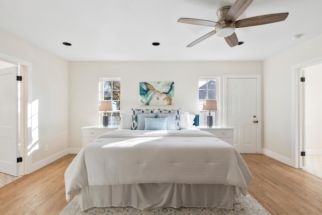 bedroom featuring light hardwood / wood-style flooring, multiple windows, and ceiling fan