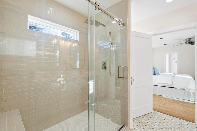 bathroom featuring ceiling fan and a shower with shower door