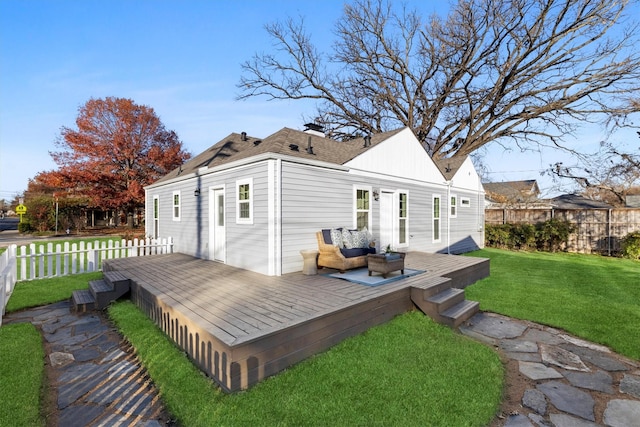 rear view of property with a wooden deck and a yard