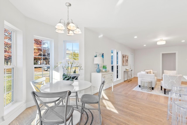 dining room with a notable chandelier and light wood-type flooring