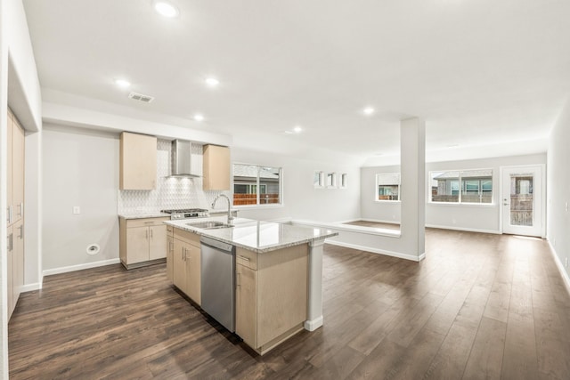kitchen featuring visible vents, dishwasher, a sink, wall chimney range hood, and a kitchen island with sink
