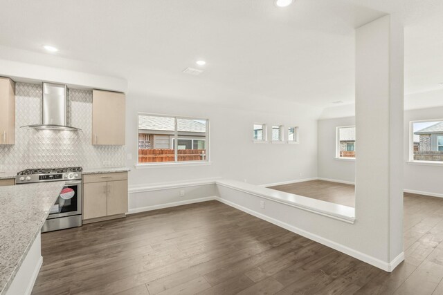 kitchen with tasteful backsplash, baseboards, wall chimney exhaust hood, dark wood-style flooring, and stainless steel gas range oven