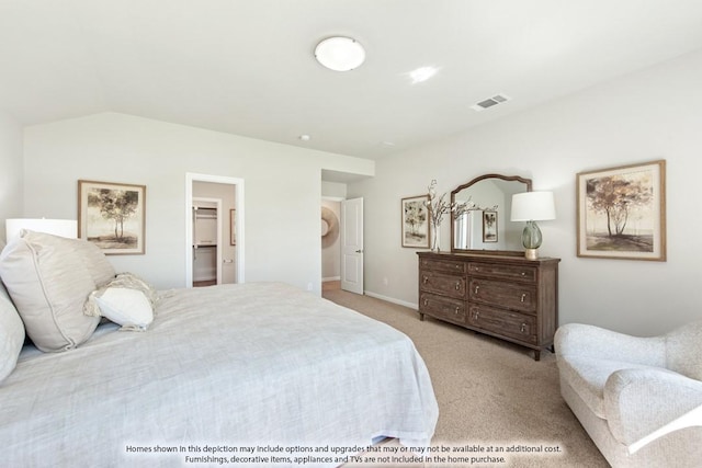 bedroom featuring lofted ceiling, a spacious closet, and light carpet