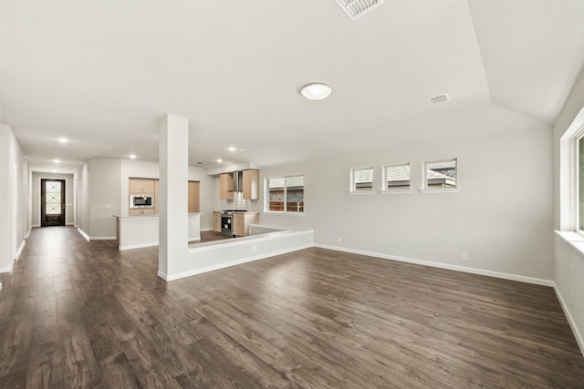 unfurnished living room with dark wood-type flooring, visible vents, baseboards, and recessed lighting