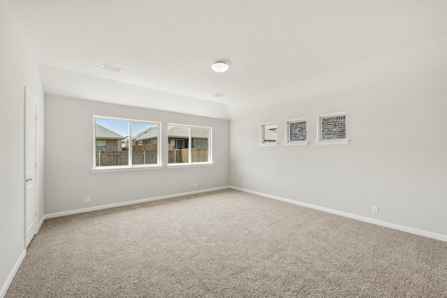 carpeted spare room featuring baseboards and visible vents