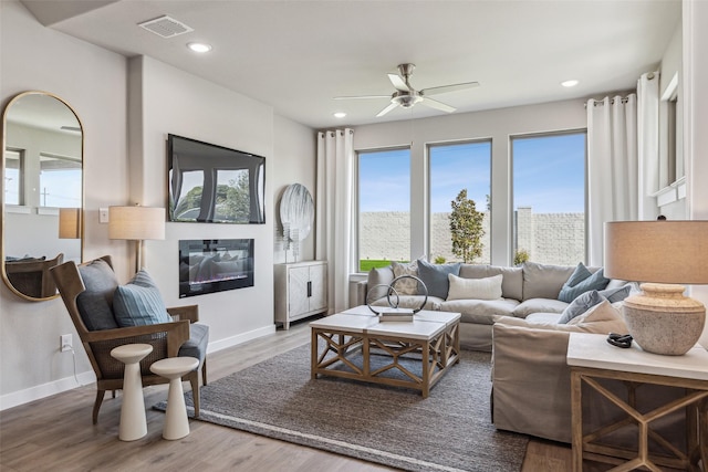 living room with wood-type flooring and ceiling fan