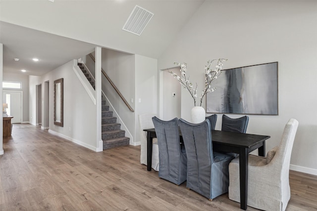 dining space featuring lofted ceiling and light wood-type flooring