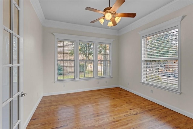 spare room featuring light wood-type flooring, a wealth of natural light, and ornamental molding