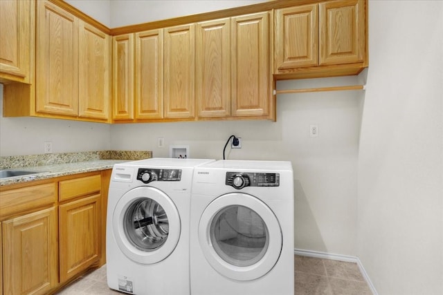 laundry area featuring cabinets, independent washer and dryer, light tile patterned floors, and sink