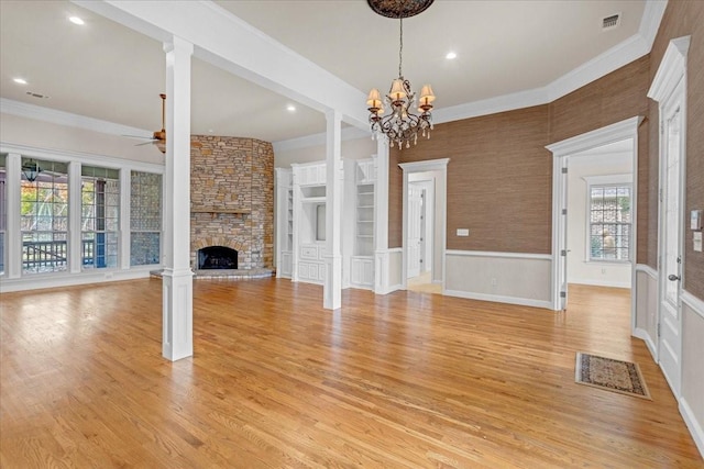 unfurnished living room featuring a stone fireplace, plenty of natural light, light hardwood / wood-style floors, and ornamental molding