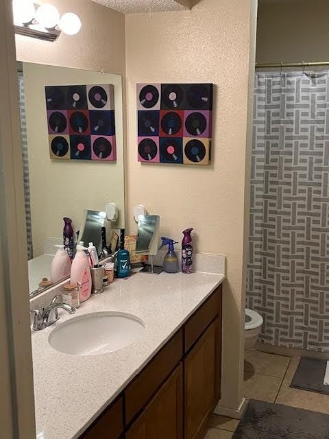 bathroom with tile patterned floors, vanity, a shower with shower curtain, and toilet