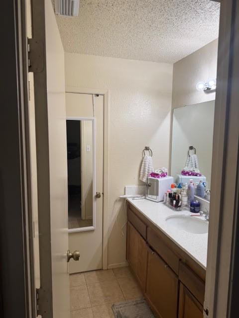 bathroom featuring vanity, a textured ceiling, and tile patterned floors