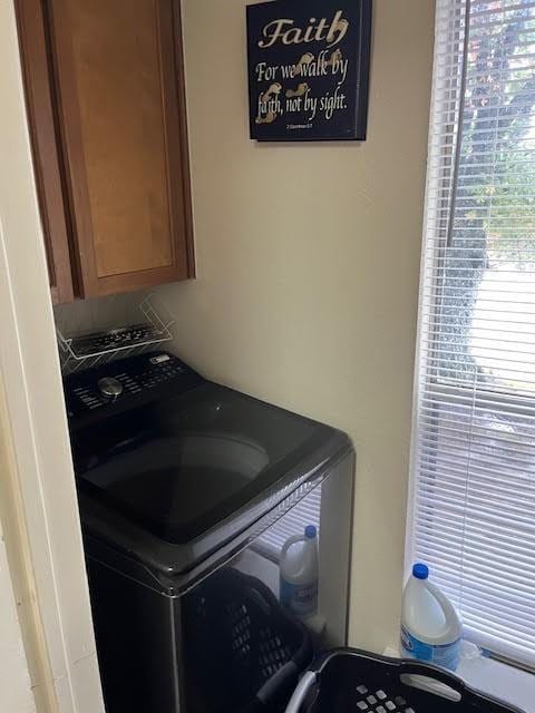 clothes washing area featuring cabinets and washer / dryer