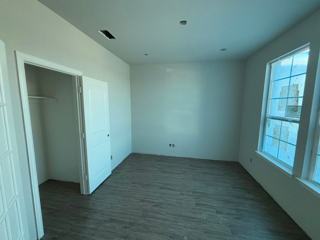 unfurnished bedroom with dark hardwood / wood-style flooring