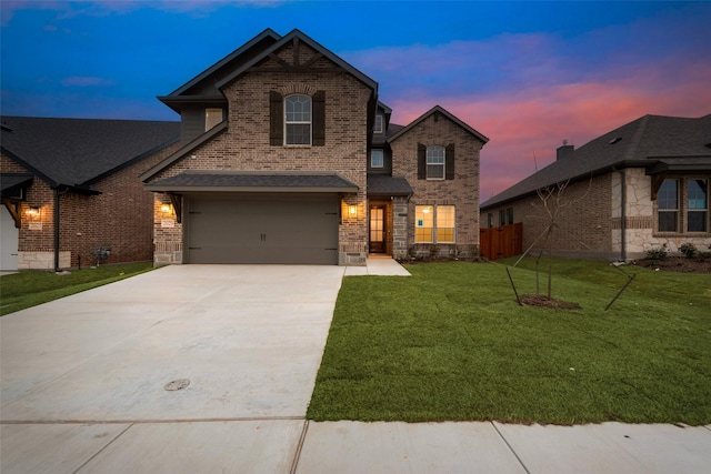 view of front of home with a garage, a yard, concrete driveway, and brick siding