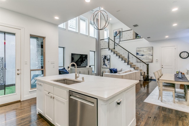 kitchen with white cabinetry, sink, dishwasher, dark wood-type flooring, and a kitchen island with sink