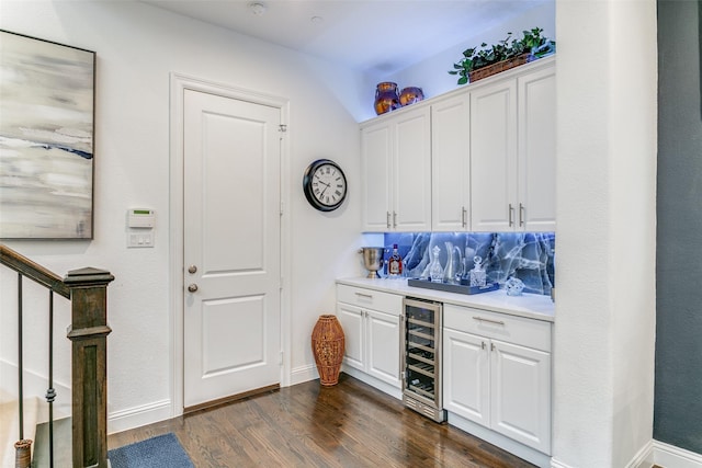 bar featuring backsplash, white cabinetry, wine cooler, and dark wood-type flooring