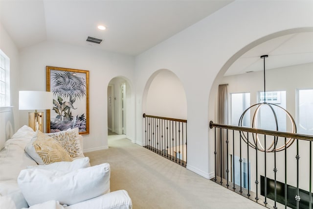 living area featuring light carpet and vaulted ceiling