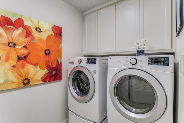 clothes washing area with cabinets and washer and dryer