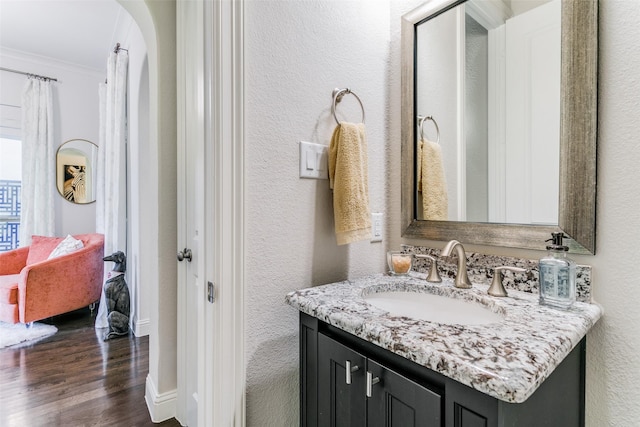 bathroom with hardwood / wood-style floors, vanity, and crown molding