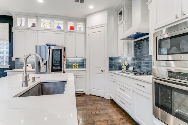 kitchen featuring premium range hood, white cabinetry, stainless steel appliances, and sink