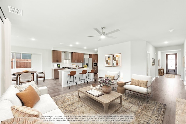 living room featuring dark wood-type flooring, ceiling fan, and sink