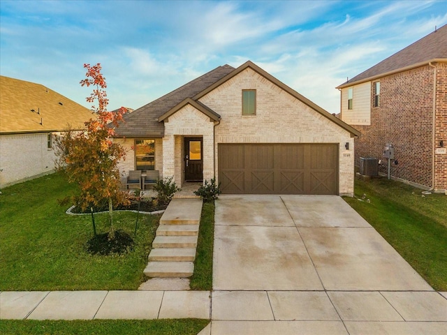 view of front of home with a garage, a front yard, and central AC unit