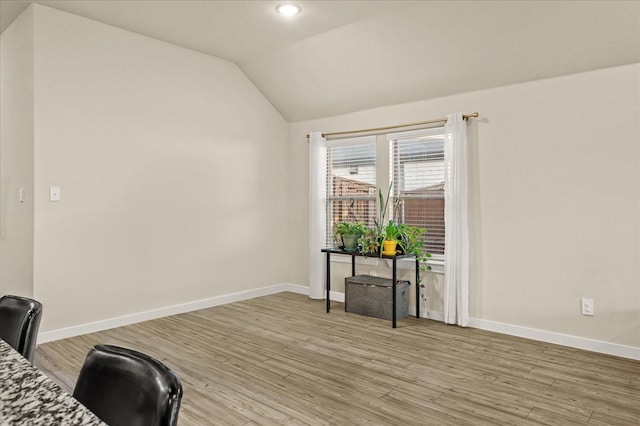 unfurnished room featuring light wood-type flooring and vaulted ceiling