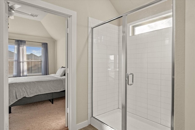 bathroom featuring vaulted ceiling, walk in shower, and a healthy amount of sunlight