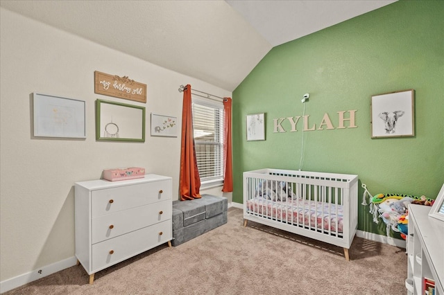 carpeted bedroom with vaulted ceiling and a nursery area